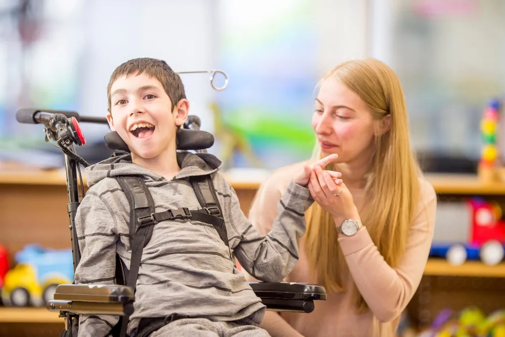 an educator holding the hand of her disabled student