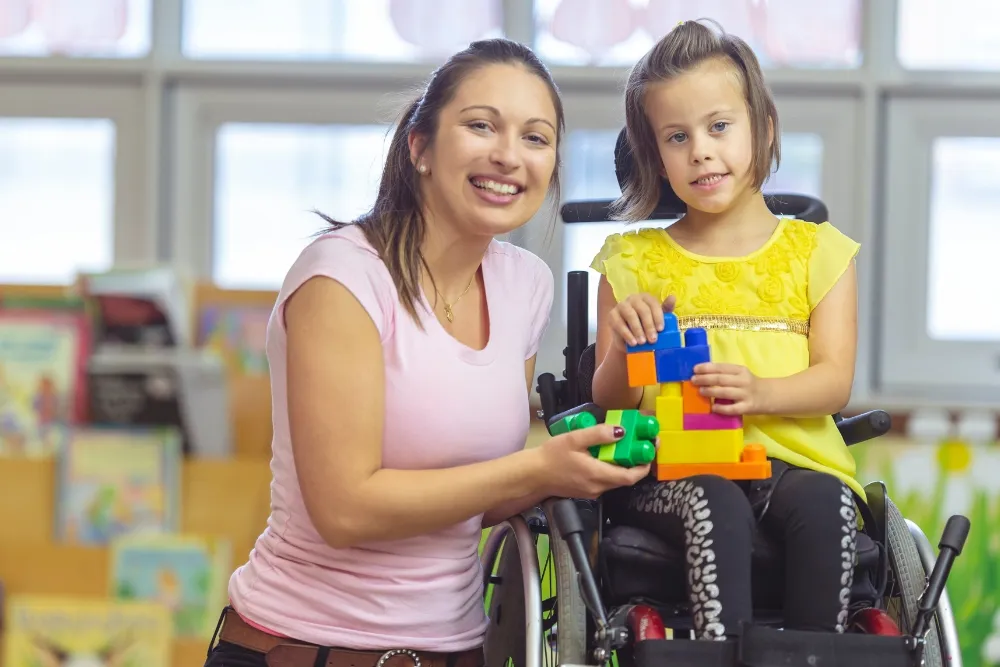 a smiling teacher together with her disabled student